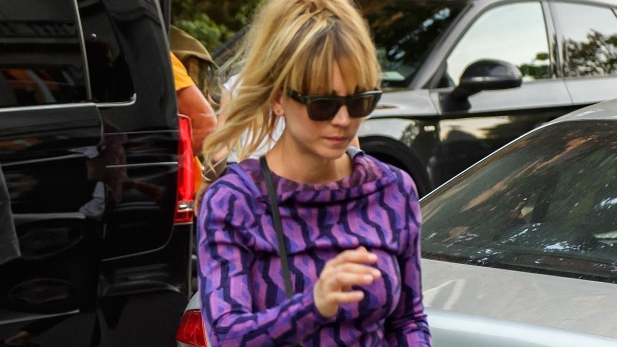 Actress Kaley Cuoco looks trendy in a purple patterned top as she is pictured arriving to her hotel in Berlin to film 'The Flight Attendant.'
