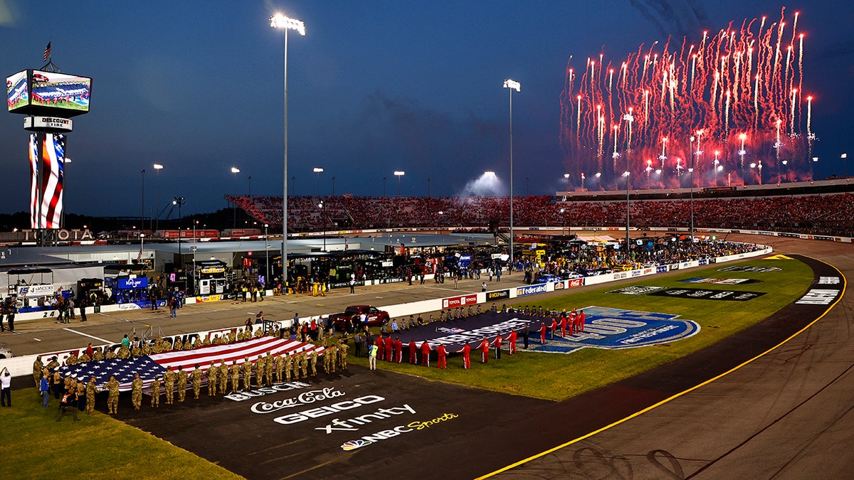 RICHMOND, VIRGINIA - SEPTEMBER 11: Fireworks erupt as members of the military and first responders hold the American and 9/11 Never Forget flag during pre-race ceremonies prior to the NASCAR Cup Series Federated Auto Parts 400 Salute to First Responders at Richmond Raceway on September 11, 2021 in Richmond, Virginia. (Photo by Jared C. Tilton/Getty Images)