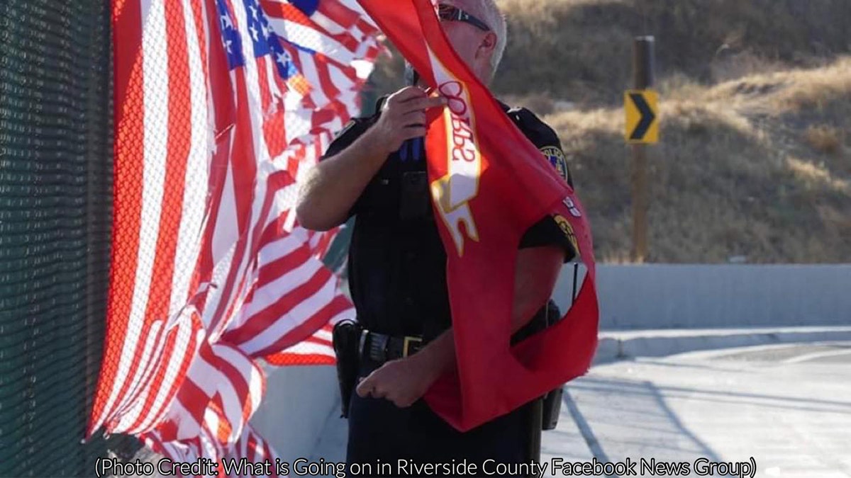 The memorial of 13 American flags and one Marine Corps flag was displayed on the fence of the Ivy Street overpass above the 91 Freeway in Riverside