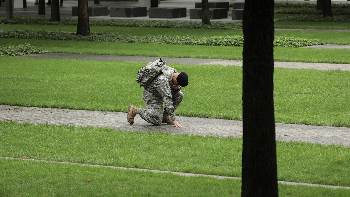 Army Reserve Sgt. Edwin Morales kneels in memory of his late friend Ruben Correa, a firefighter who died during 9/11, at the National September 11 Memorial. "Out of the literal ashes grew hope, unity and a renewed sense of community and country," said one faith leader to Fox News Digital.