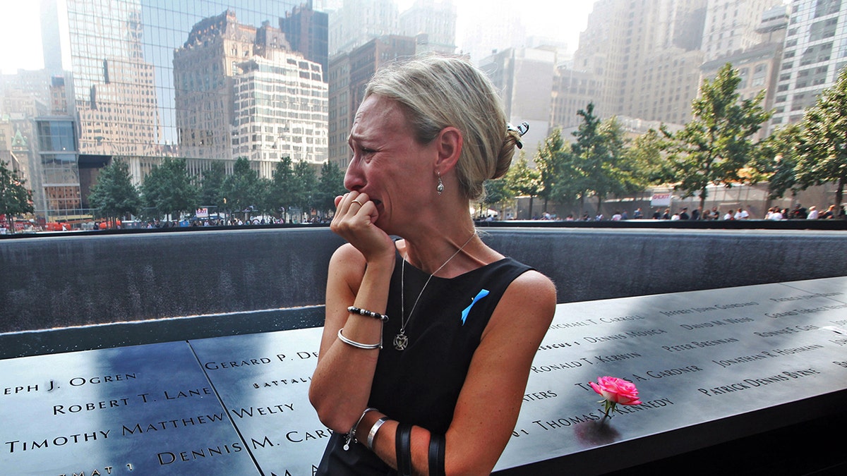 NEW YORK, NY - SEPTEMBER 11:  Carrie Bergonia of Pennsylvania looks over the name of her fiance, firefighter Joseph Ogren at the 9/11 Memorial during ceremonies for the twelfth anniversary of the terrorist attacks on lower Manhattan at the World Trade Center site on September 11, 2013 in New York City. 