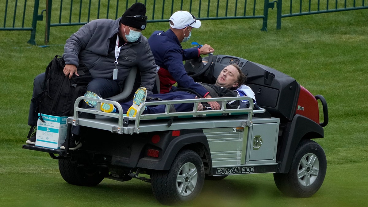 Tom Felton is helped after collapsing on the 18th hole during a practice day at the Ryder Cup at the Whistling Straits Golf Course