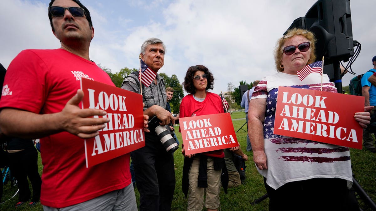 Demonstrators hold signs near members of the media before a rally near the U.S. Capitol in Washington, Saturday, Sept. 18, 2021. The rally was planned by allies of former President Donald Trump and aimed at supporting the so-called "political prisoners" of the Jan. 6 insurrection at the U.S. Capitol. (AP Photo/Brynn Anderson)
