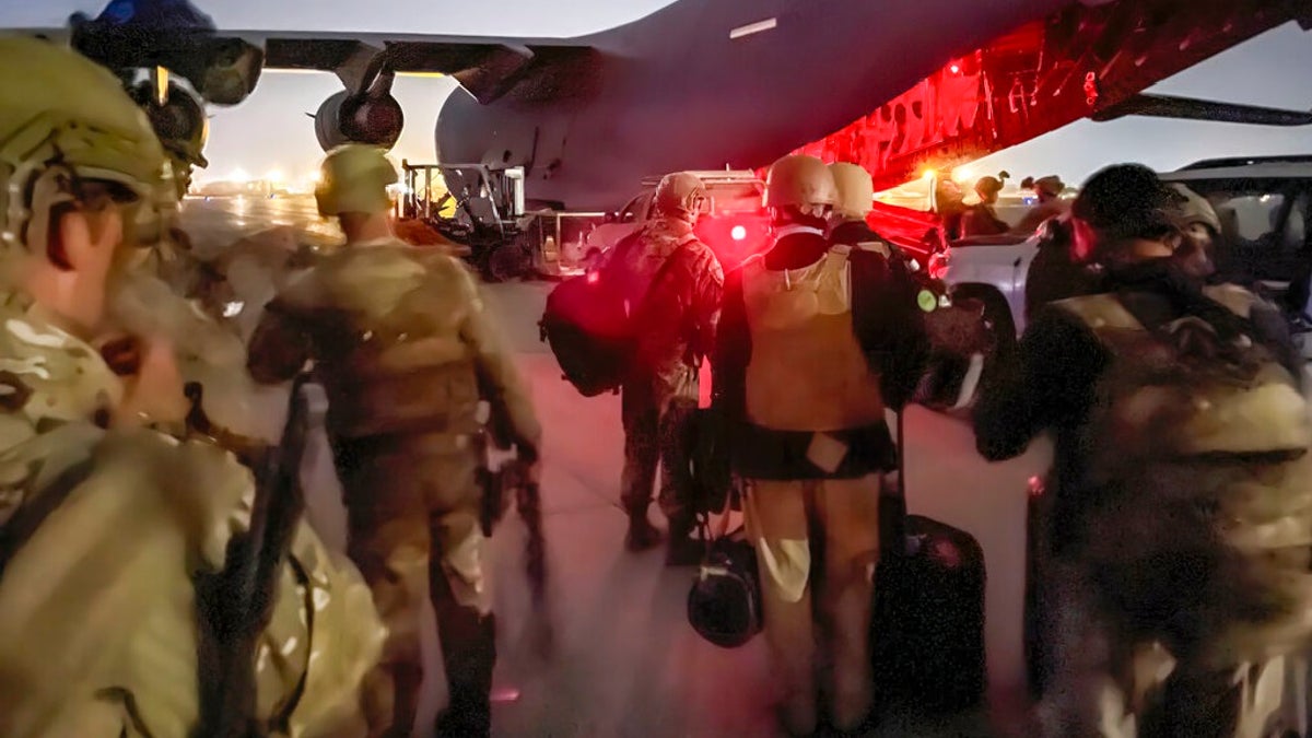 In this image provided by the U.S. Army, paratroopers assigned to the 82nd Airborne Division, and others, prepare to board a C-17 cargo plane at Hamid Karzai International Airport in Kabul, Afghanistan, on Monday.?