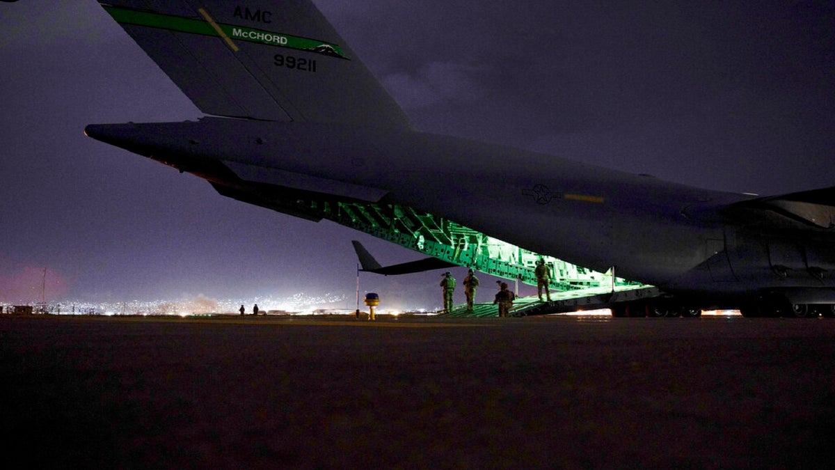 An Air Force aircrew, assigned to the 816th Expeditionary Airlift Squadron, prepares to receive soldiers, assigned to the 82nd Airborne Division, to board a U.S. Air Force C-17 Globemaster III aircraft in support of the final noncombatant evacuation operation missions at Hamid Karzai International Airport in Kabul Afghanistan.