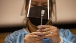A healthcare worker prepares a dose of the Pfizer-BioNTech Covid-19 vaccine at a mobile vaccination clinic at a high school in Los Angeles, California, U.S., on Monday, Aug. 30, 2021. The Los Angeles Unified School District announced last week it is launching mobile clinics to vaccinate any eligible students and employees against Covid-19. Photographer: Jill Connelly/Bloomberg via Getty Images