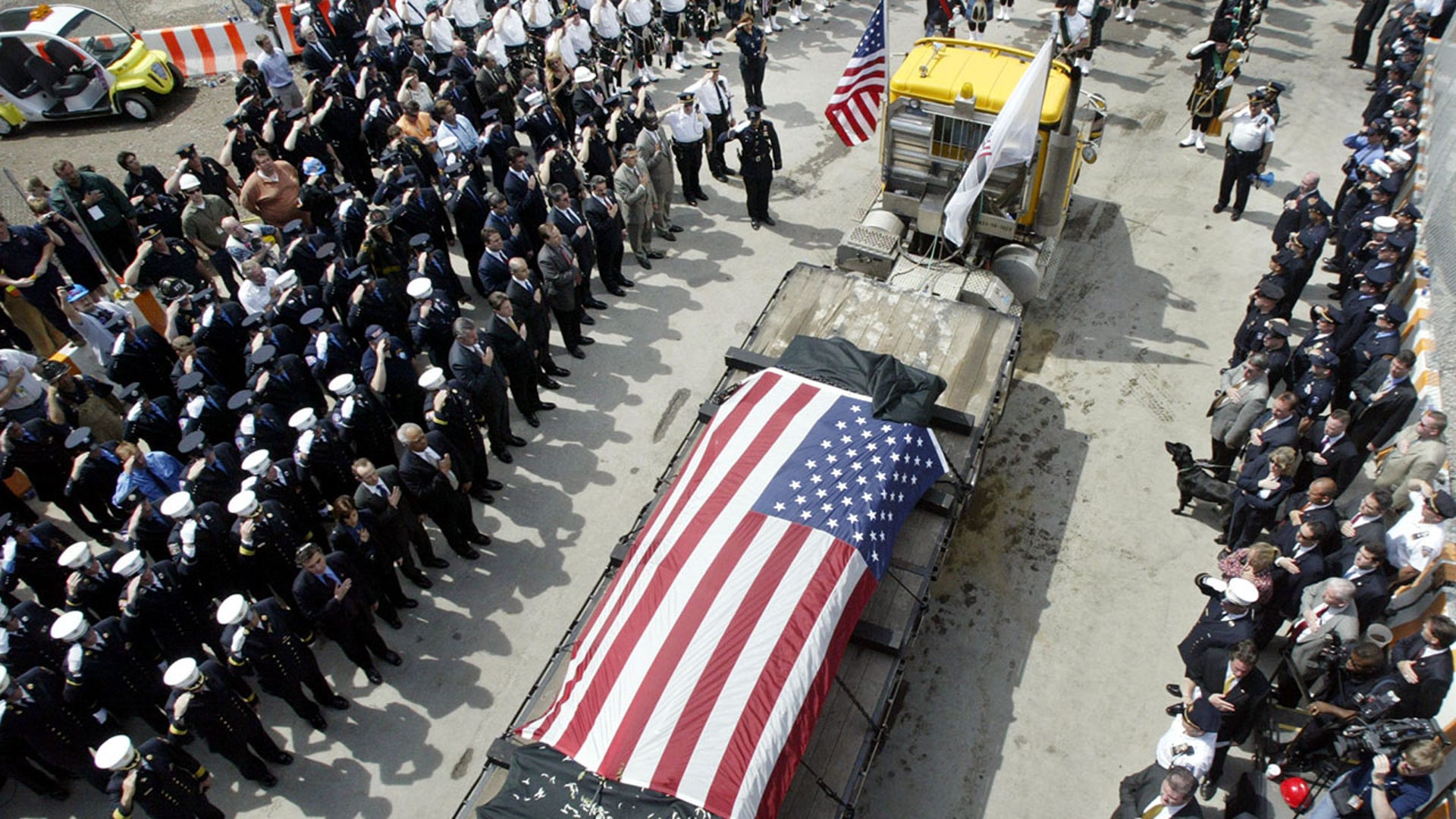 The last steel girder left standing at the World Trade Center, covered with black cloth and an American flag, is carried from the World Trade Center site in New York on May 30, 2002, marking the completion of recovery work from the Sept. 11, 2001, attacks on the twin towers.  New York marked the end of the mammoth recovery of human remains and disposal of the ruins of the World Trade Center with a brief ceremony, nearly nine months after two hijacked planes slammed into the twin towers, destroying them and killing 2,823 people.