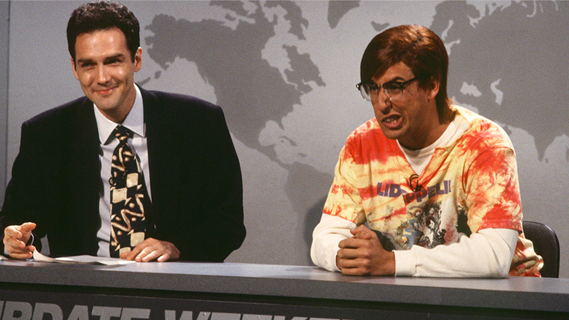 SATURDAY NIGHT LIVE -- Episode 1 -- Air Date 09/24/1994 -- Pictured: (l-r) Norm MacDonald, Adam Sandler as Gil Graham during "Weekend Update" on September 24, 1994  