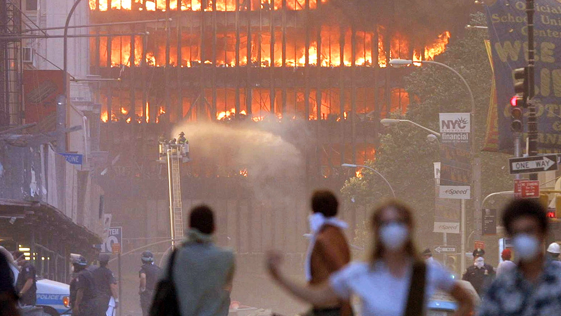 People walk in the street in the area where the World Trade Center buildings collapsed Sept. 11, 2001, after two airplanes slammed into the twin towers in a terrorist attack. (Photo by Mario Tama/Getty Images)