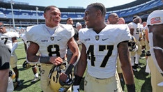 Army football players run out on field carrying American flags