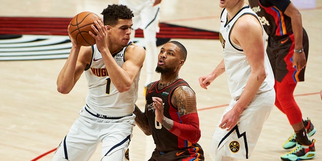 Portland Trail Blazers guard Damian Lillard (0) defends Denver Nuggets forward Michael Porter Jr.. (1) in the first half during game six in the first round of the 2021 NBA Playoffs. at Moda Center.