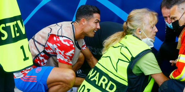 Soccer Soccer - UEFA Champions League - Group F - BSC Young Boys v Manchester United - Stadion Wankdorf, Bern, Switzerland - September 14, 2021 Cristiano Ronaldo of Manchester United checks a flight attendant after being hit by a ball during the warm-up before the REUTERS match / Arnd Wiegmann