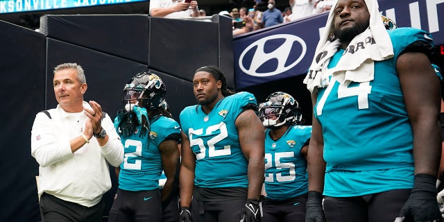 Jacksonville Jaguars coach Urban Meyer, left, prepares to lead his team onto the field before an NFL football game against the Houston Texans Sunday, Sept. 12, 2021, in Houston.