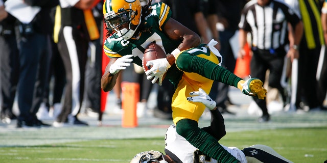 Green Bay Packers wide receiver Davante Adams (17) catches a pass as New Orleans Saints cornerback Marshon Lattimore tries to stop him during the first half of an NFL football game, 日曜日, 9月. 12, 2021, in Jacksonville, フラ. (AP Photo/Stephen B. Morton)