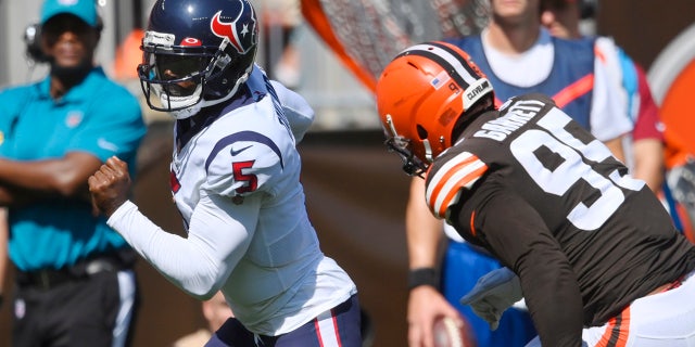 Houston Texans quarterback Tyrod Taylor (5) rushes for a 15-yard touchdown against Cleveland Browns defensive end Myles Garrett (95) during the first half of an NFL football game, Sunday, Sept. 19, 2021, in Cleveland.