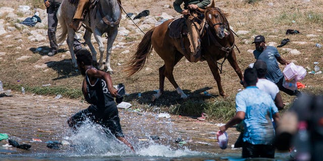 Sept. 19, 2021: U.S. Customs and Border Protection mounted officers attempt to contain migrants as they cross the Rio Grande from Ciudad Acuña, Mexico, into Del Rio, Texas. (AP Photo/Felix Marquez)