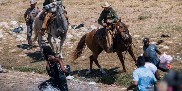 U.S. Customs and Border Protection mounted officers attempt to contain migrants as they cross the Rio Grande from Ciudad Acuña, Mexico, into Del Rio, Texas, Sunday, Sept. 19, 2021. 