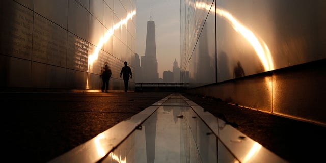 A man walks through the Empty Sky memorial on September 11 at dawn opposite Lower Manhattan in New York City and the One World Trade Center in Liberty State Park in Jersey City, New Jersey, USA on September 11, 2013. 