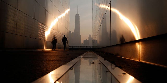 A man walks through the 9/11 Empty Sky memorial at sunrise across from New York's Lower Manhattan and One World Trade Center in Liberty State Park in Jersey City, New Jersey, U.S. September 11, 2013. 