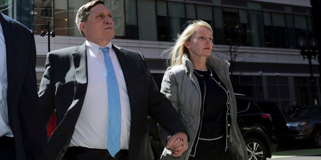 In this April 3, 2019 file photo, investor John Wilson, left, arrives at federal court in Boston with his wife Leslie to face charges in a nationwide college admissions bribery scandal. 