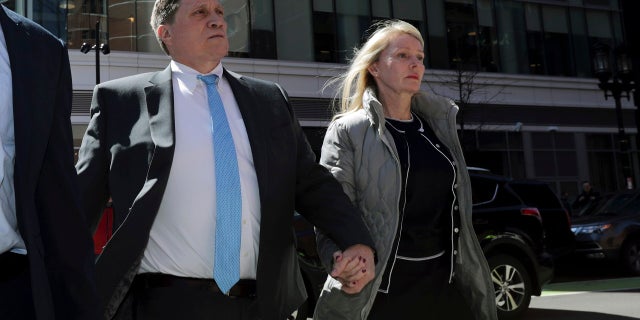 Investor John Wilson, left, arrives at federal court in Boston with his wife Leslie, in April 2019, to face charges in a nationwide college admissions bribery scandal.