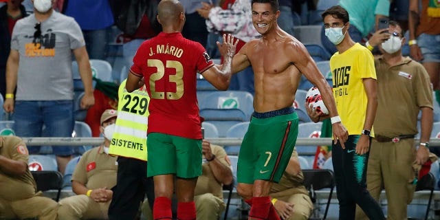 Portugal's Cristiano Ronaldo, right, celebrates after scoring his side's second goal during the World Cup 2022 group A qualifying soccer match between Portugal and the Republic of Ireland at the Algarve stadium outside Faro, Portugal, Wednesday, Sept. 1, 2021. (AP Photo/Armando Franca)