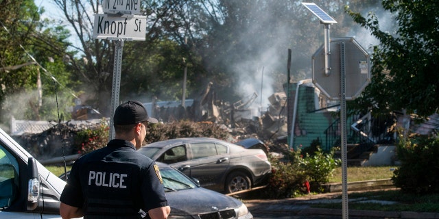 A Manville Police Officer stands guard near the remains of a house that exploded due to severe flooding from Tropical Storm Ida in Manville, NJ., Friday. Dozens of people in five states died as storm water cascaded into people’s homes and engulfed automobiles, overwhelming urban drainage systems never meant to handle so much rain in such a short time.