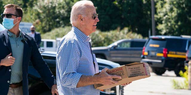 President Biden carries a box of pizza as he visits union members at the International Brotherhood of Electrical Workers Local 313 in Newcastle, Delaware to mark Labor Day on Monday, September 6, 2021.