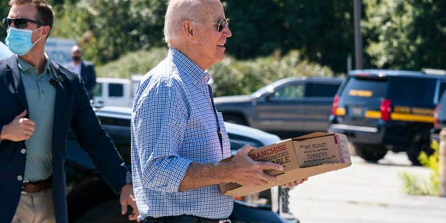 President Biden carries a box of pizza as he visits union members at the International Brotherhood of Electrical Workers Local 313 in Newcastle, Delaware to mark Labor Day on Monday, September 6, 2021.