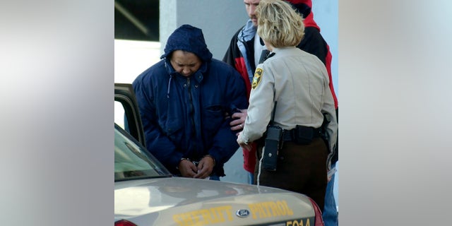 In this Dec. 3, 2003 file photo, Alfonso Rodriguez Jr., left, is helped into a sheriff's car after waiving extradition at the Polk County Courthouse in Crookston, Minnesota.