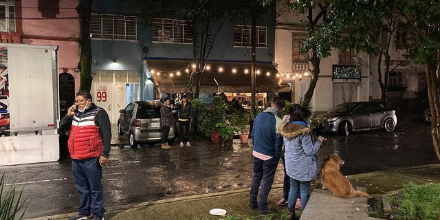 People gather outside on the sidewalk after a strong earthquake was felt, in the Roma neighborhood of Mexico City, Tuesday, Sept. 7, 2021.  (AP Photo/Leslie Mazoch)