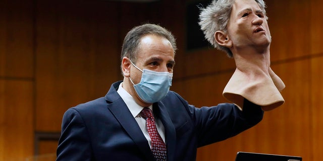 Deputy District Attorney Habib A. Balian holds a rubber latex mask, worn by Robert Durst when police arrested him, Wednesday, Sept. 8, 2021 in Inglewood, Calif. (Al Seib/Los Angeles Times via AP, Pool)
