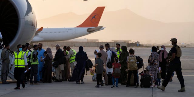 Foreigners board a Qatar Airways plane at the airport in Kabul, Afghanistan.  9, 2021.