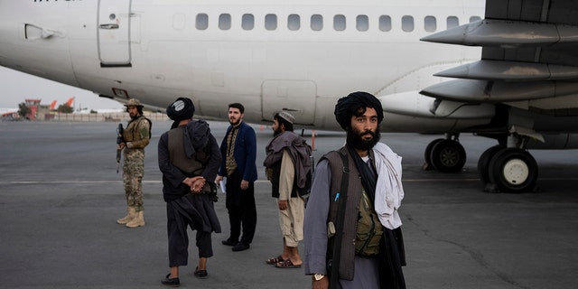 Taliban personnel stand beside a plane at the airport in Kabul, Afghanistan, Thursday, Sept. 9, 2021. (AP Photo/Bernat Armangue)