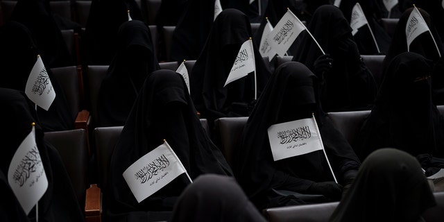 Women wave Taliban flags as they sit in an auditorium at the Kabul University Education Center during a demonstration in support of the Taliban government in Kabul, Afghanistan, Saturday September 11, 2021. 