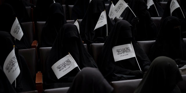 Women wave Taliban flags as they sit inside an auditorium at Kabul University's education center during a demonstration in support of the Taliban government in Kabul, Afghanistan, Saturday, Sept. 11, 2021. 