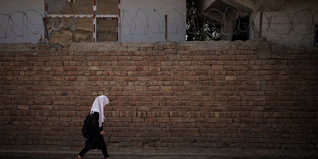 A girl walks to school before class in Kabul, Afghanistan, Sunday, Sept. 12, 2021.