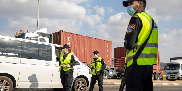 Israeli police check cars with Palestinian laborers as they search for two Palestinians who broke out of a maximum-security prison last week, on a road leading to the West Bank town of Jenin, near Gan Ner Israel, Sunday, Sept. 12, 2021. (AP Photo/Ariel Schalit)