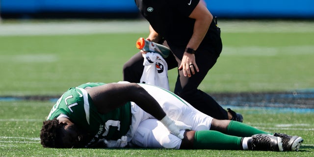 New York Jets offensive tackle Mekhi Becton is helped during the Panthers game on Sept.  12, 2021, in Charlotte, North Carolina.