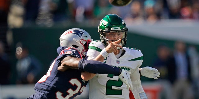 New York Jets quarterback Zach Wilson throws under pressure from New England Patriots' Joejuan Williams Sunday, Sept. 19, 2021, in East Rutherford, New Jersey.
