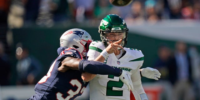 New York Jets quarterback Zach Wilson throws under pressure from New England Patriots' Joejuan Williams Sunday, Sept. 19, 2021, in East Rutherford, New Jersey. 