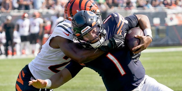 Chicago Bears quarterback Justin Fields (1) carries the ball and is tackled by Cincinnati Bengals cornerback Chidobe Awuzie during the second half of an NFL football game Sunday, Sept. 19, 2021, in Chicago.