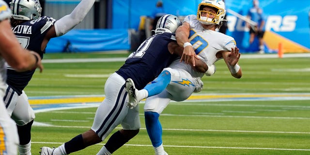 Los Angeles Chargers quarterback Justin Herbert is hit by Dallas Cowboys linebacker Micah Parsons as he throws during the second half of an NFL football game Sunday, Sept. 19, 2021, in Inglewood, Calif. (AP Photo/Gregory Bull)