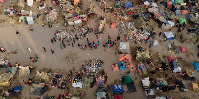 Migrants, many from Haiti, are seen at an encampment along the Del Rio International Bridge near the Rio Grande, Tuesday, Sept. 21, 2021, in Del Rio, Texas. The options remaining for thousands of Haitian migrants straddling the Mexico-Texas border are narrowing as the United States government ramps up to an expected six expulsion flights to Haiti and Mexico began busing some away from the border. (AP Photo/Julio Cortez)