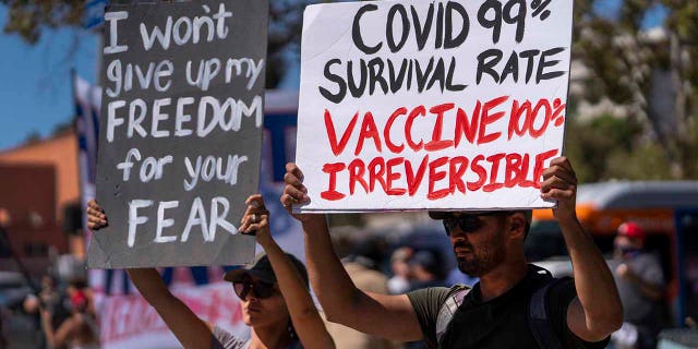 Protesters opposing COVID-19 vaccine mandates holding a rally in front of City Hall in downtown Los Angeles on Sept. 18