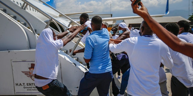 Haitians deported from the United States attempt to board the same plane in which they were deported, in an attempt to return to the United States on the tarmac of Toussaint Louverture Airport in Port-au-Prince, Haiti, Tuesday, September 21, 2021. (AP Photo / Joseph Odelyn)