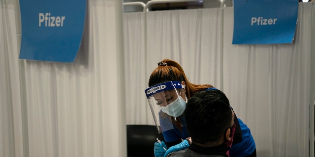 In this May 21, 2021, file photo, licensed vocational nurse Angeline Gabuten administers the Pfizer COVID-19 vaccine to a patient at Providence Edwards Lifesciences vaccination site in Santa Ana, Calif.