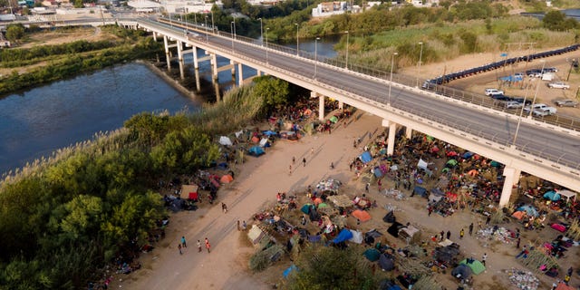 FILE - In this Tuesday, Sept. 21, 2021, file photo, migrants, many from Haiti, are seen at an encampment along the Del Rio International Bridge near the Rio Grande in Del Rio, Texas. (AP Photo/Julio Cortez, File)