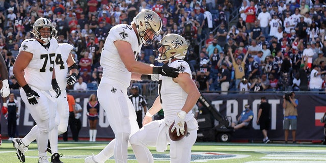 New Orleans Saints quarterback Taysom Hill is congratulated by tight end Garrett Griffin after his touchdown against the New England Patriots on Sept. 26, 2021, in Foxborough, Massachusetts.