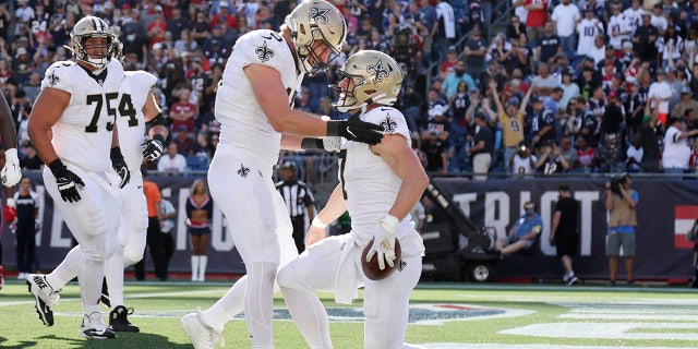 New Orleans Saints quarterback Taysom Hill is congratulated by tight end Garrett Griffin after his touchdown against the New England Patriots on Sept. 26, 2021, in Foxborough, Massachusetts.
